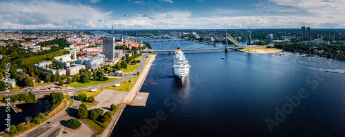 Riga, Latvia. July 18, 2022. Aerial drone view of the large cruise ship in Riga port, Latvia view to the old town and city center.