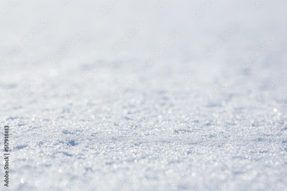 White snow close-up. Winter background with snow texture. Shallow depth of field and blur. Perfect for Christmas and New Year design. View with copy space.