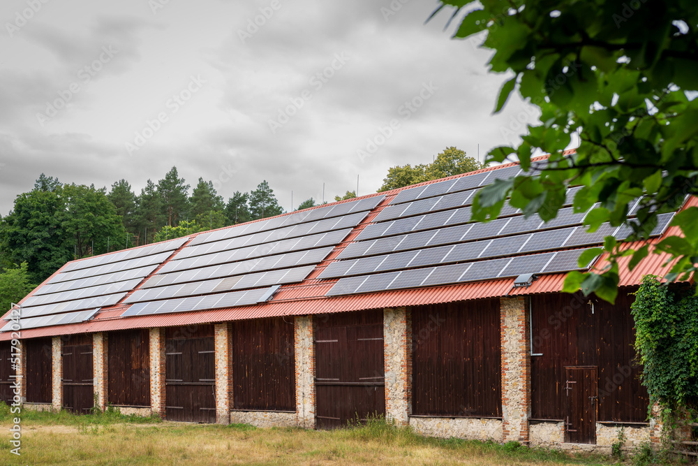 A huge brick barn with solar panels on the roof. Horse stud in Florianka. Beautiful rural landscape A huge brick barn with solar panels on the roof. Horse stud in Florianka. Beautiful rural landscape