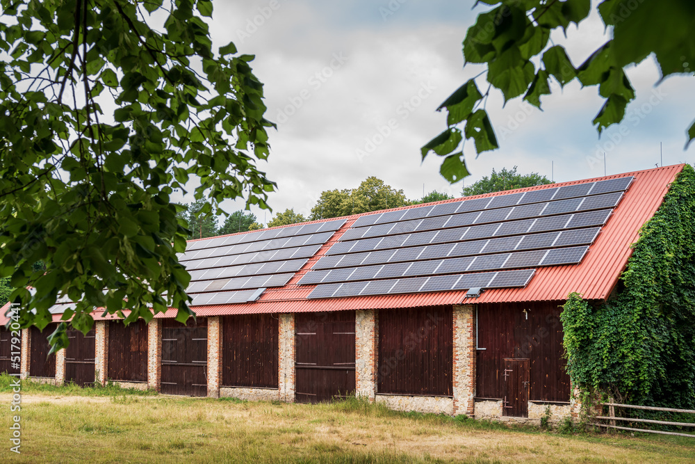 A huge brick barn with solar panels on the roof. Horse stud in Florianka. Beautiful rural landscape