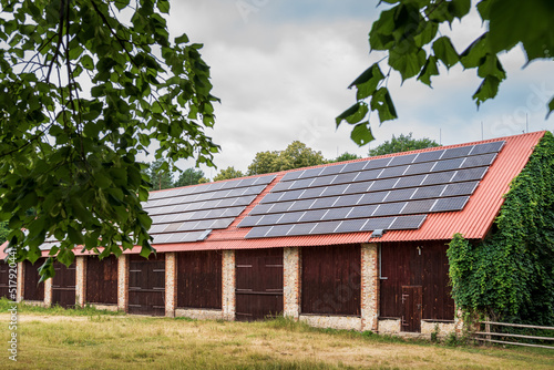 Obraz na płótnie A huge brick barn with solar panels on the roof. Horse stud in Florianka. Beautiful rural landscape w salonie