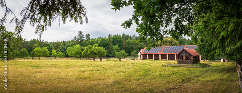Obraz na płótnie Panorama of the run for horses. Brick barn with photovoltaic panels on a corrugated roof. Beautiful rural landscape. Zwierzyniec, Poland w salonie