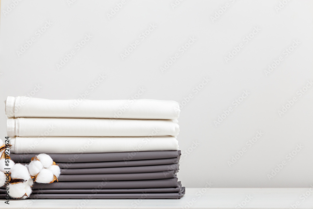 Gray and white bed linen, cotton branch sheets on the table Gray and white bed linen, cotton branch sheets on the table