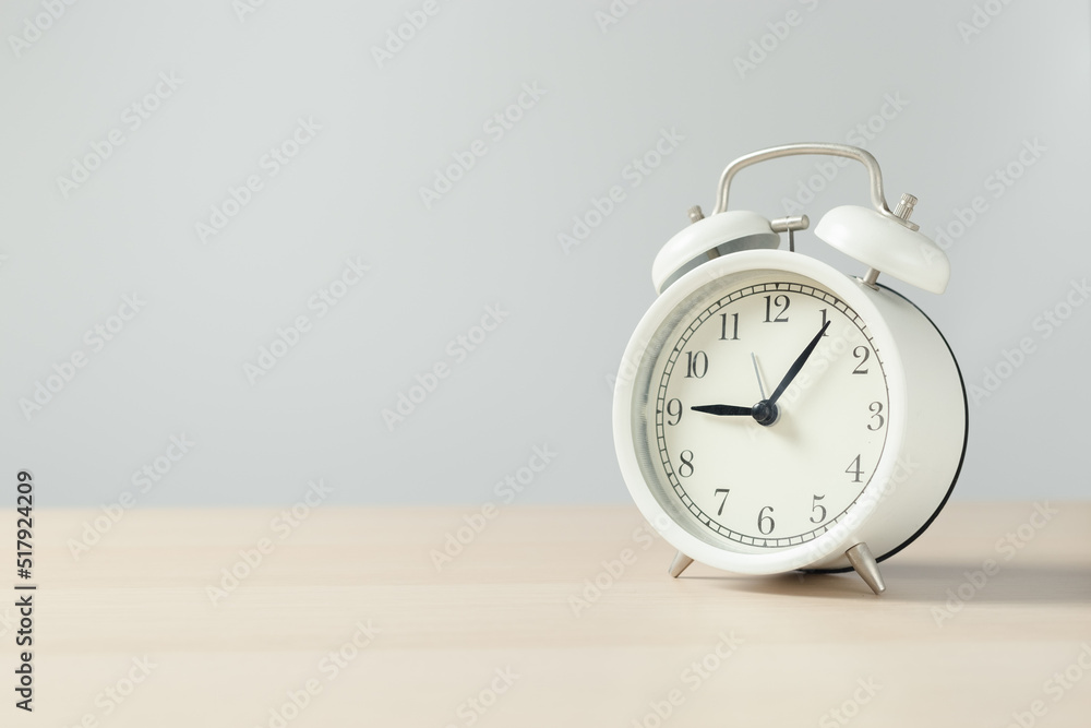 white retro alarm clock on wooden table. white retro alarm clock on wooden table.