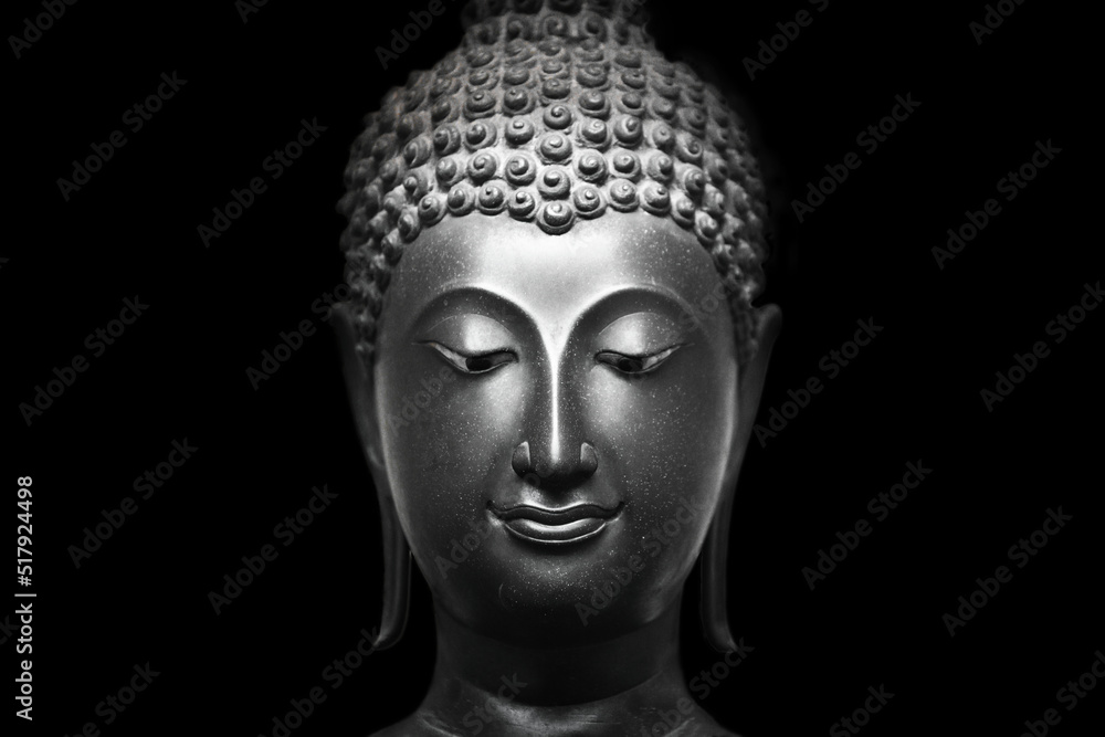 The head of an ancient Buddha statue was made of bronze. image on copy space black background.