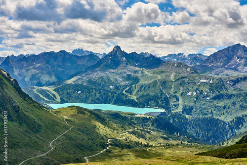 mountain landscape with cloud sky in the silvretta mountain range above cyan colored Barrier Lake Kopsseenear Galt  r  Tyrol  Austria