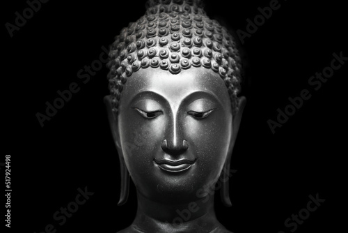 The head of an ancient Buddha statue was made of bronze. image on copy space black background.