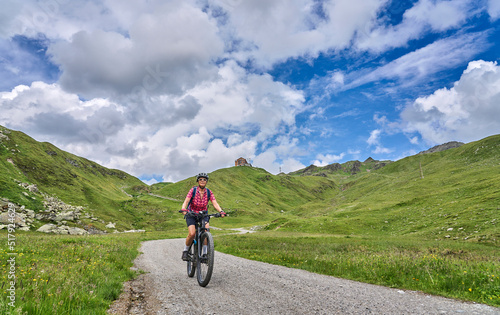nice active senior woman riding her electric mountain bike in the silvretta mountain range near Gaschurn  Tyrol  Austria