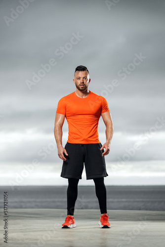 Athletic man doing fitness exercises on the ocean beach