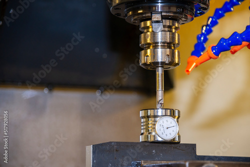 The tool length measurement with dial gauge on CNC milling machine. photo