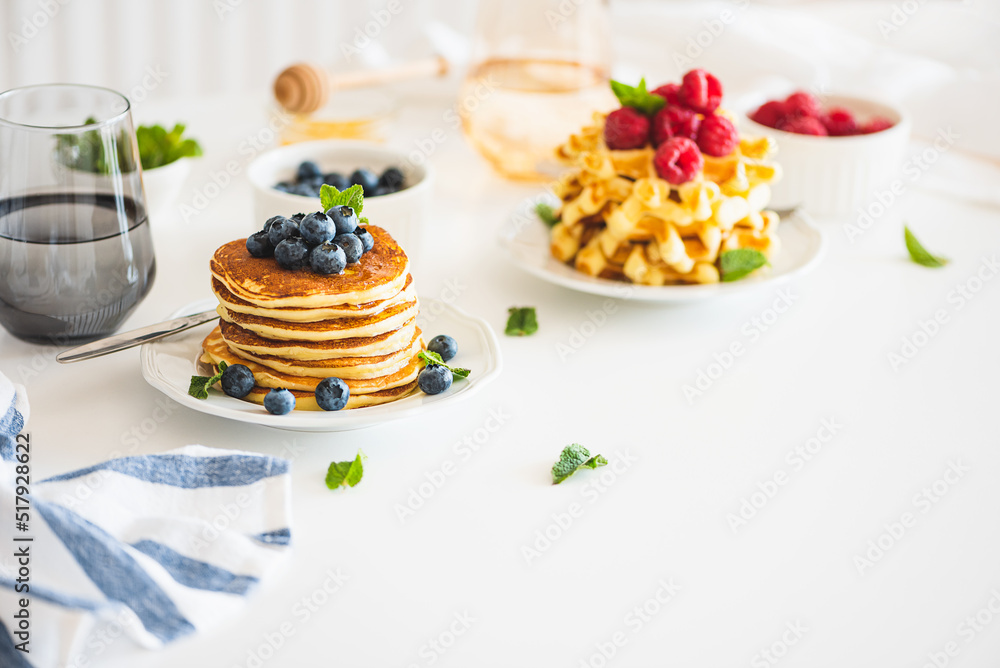 Summer breakfast. Homemade baked ricotta pancakes and Belgian waffles with fresh berries on white wooden table - obrazy, fototapety, plakaty 