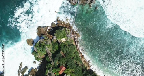 drone flight looking down on the cliffs of timang  coral island yogyakarta indonesia where the ocean waves break foaming on the rocks of the shores photo