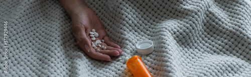 Fotografie cropped view of depressed woman with climax holding pills in hand, banner