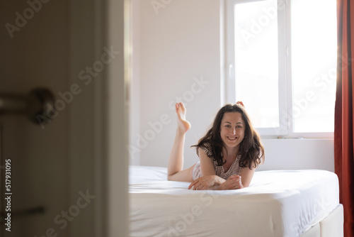 Girl lies on bed  smiling woman in bedroom