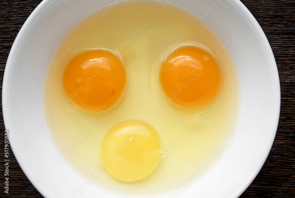 top view of raw egg yolks yellow and orange in a white plate, cooking homemade scrambled eggs or omelet. The concept of cooking healthy food. top view of raw egg yolks yellow and orange in a white plate, cooking homemade scrambled eggs or omelet. The concept of cooking healthy food.