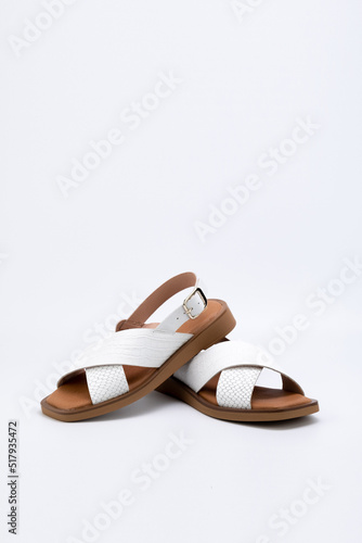 White women sandals shoes pair isolated on light grey background.