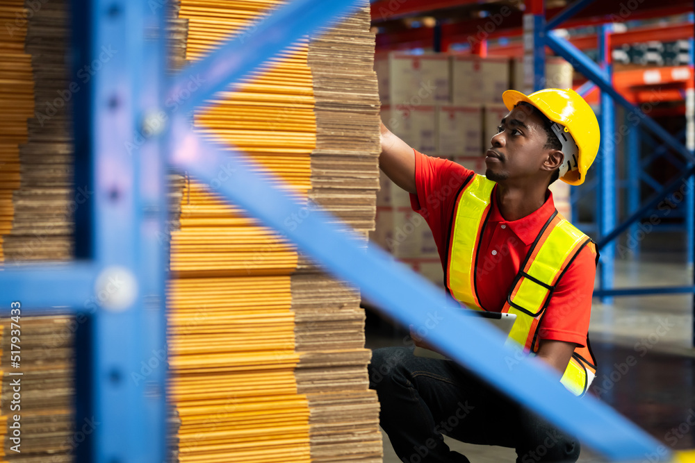 A man in charge of a large warehouse is checking the number of items in the warehouse that he is responsible for.