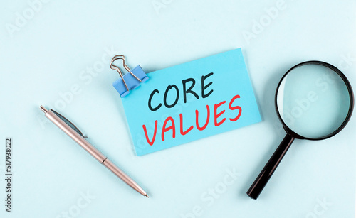 CORE VALUES text written on sticky with magnifier and pen, business concept