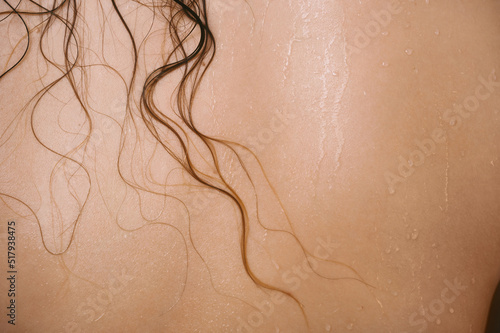 Closeup of female back with wet hair strands