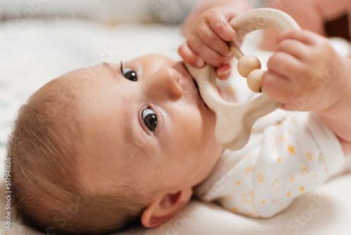 Obraz na plátně The child is gnawing on a wooden toy, a teether