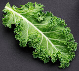 Kale salad leaf isolated on black background, top view