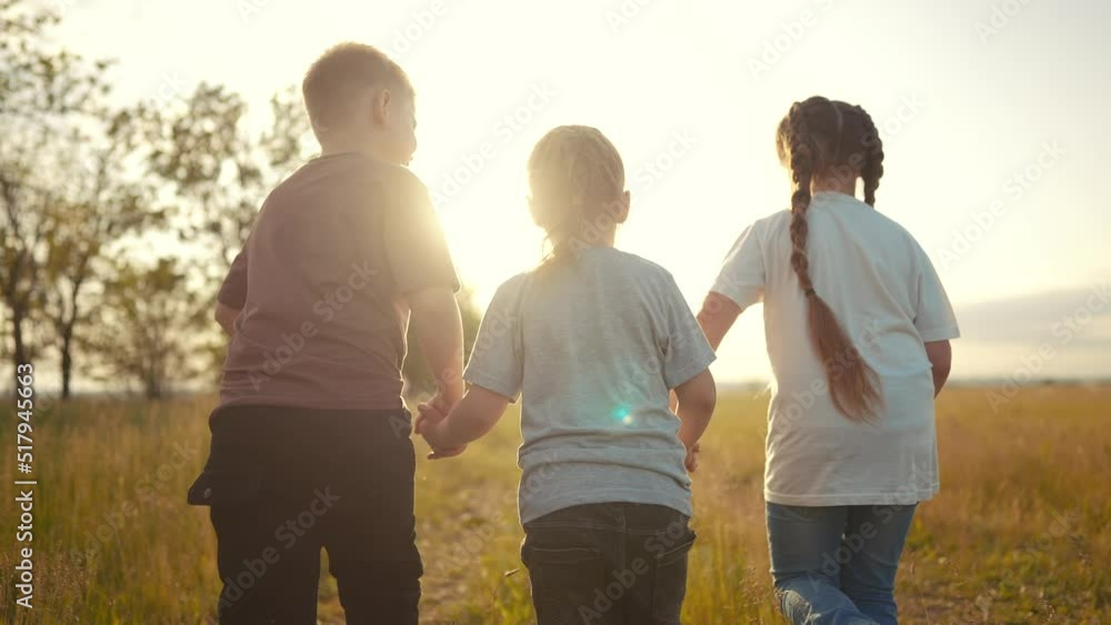 children running in the park holding hands. happy family kindergarten kid dream concept. team of children hold hands run work as a team. lifestyle children kid run in the park children running in the park holding hands. happy family kindergarten kid dream concept. team of children hold hands run work as a team. lifestyle children kid run in the park
