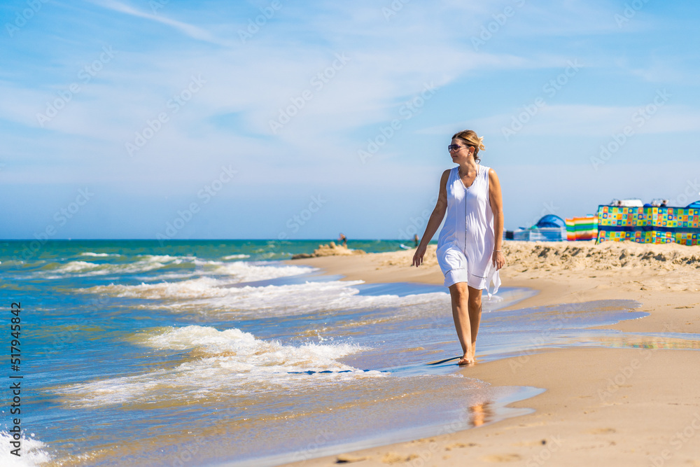 Woman walking on sunny beach
Woman walking on sunny beach