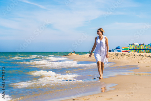 Woman walking on sunny beach 