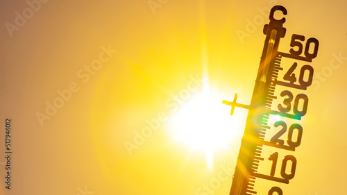 Hot weather - Heat wave / Summer heat background - Thermometer yellow orange sky and sun rays