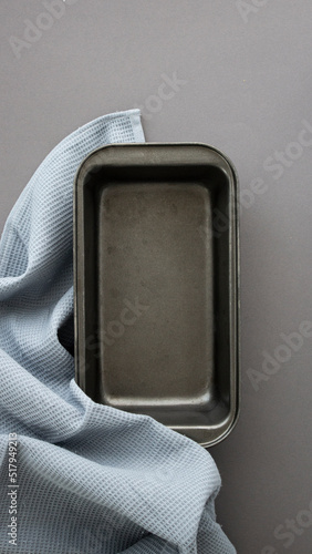 cupcake baking pan empty on gray table with blue towel
