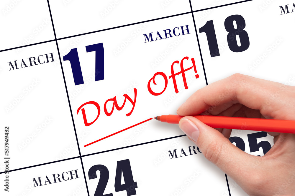 Hand writing text DAY OFF and drawing a line on calendar date 17 March. Vacation planning concept. Hand writing text DAY OFF and drawing a line on calendar date 17 March. Vacation planning concept.