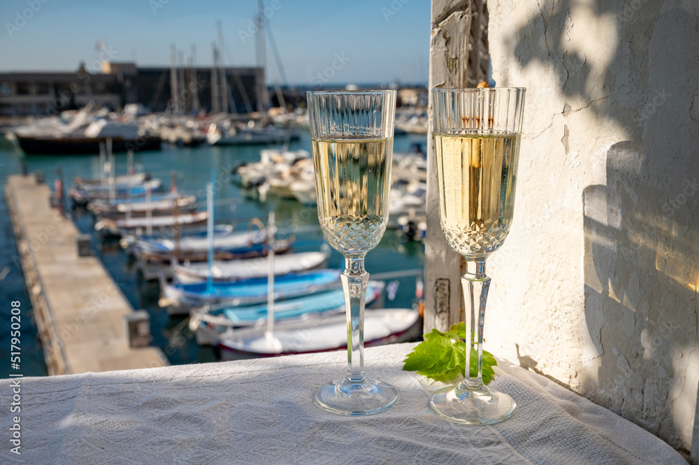 Obraz premium Birthday celebration with two glasses of French champagne sparkling wine and view on colorful fisherman's boats in old harbour in Cassis, Provence, France