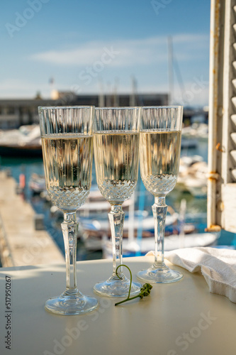 Three glasses of French champagne sparkling wine and view on colorful fisherman s boats in old harbour in Cassis  Provence  France