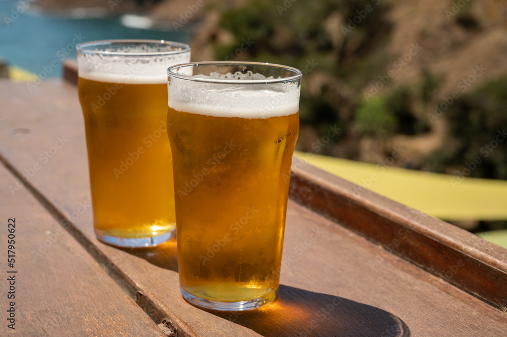 Two glasses of fresh cold lager beer served outdoor in snack bar with view on Calanque de Figuerolles in La Ciotat, Provence, France