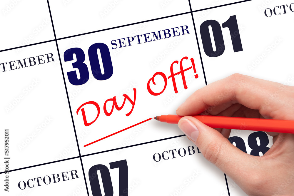 Hand writing text DAY OFF and drawing a line on calendar date 30 September . Vacation planning concept. Hand writing text DAY OFF and drawing a line on calendar date 30 September . Vacation planning concept.
