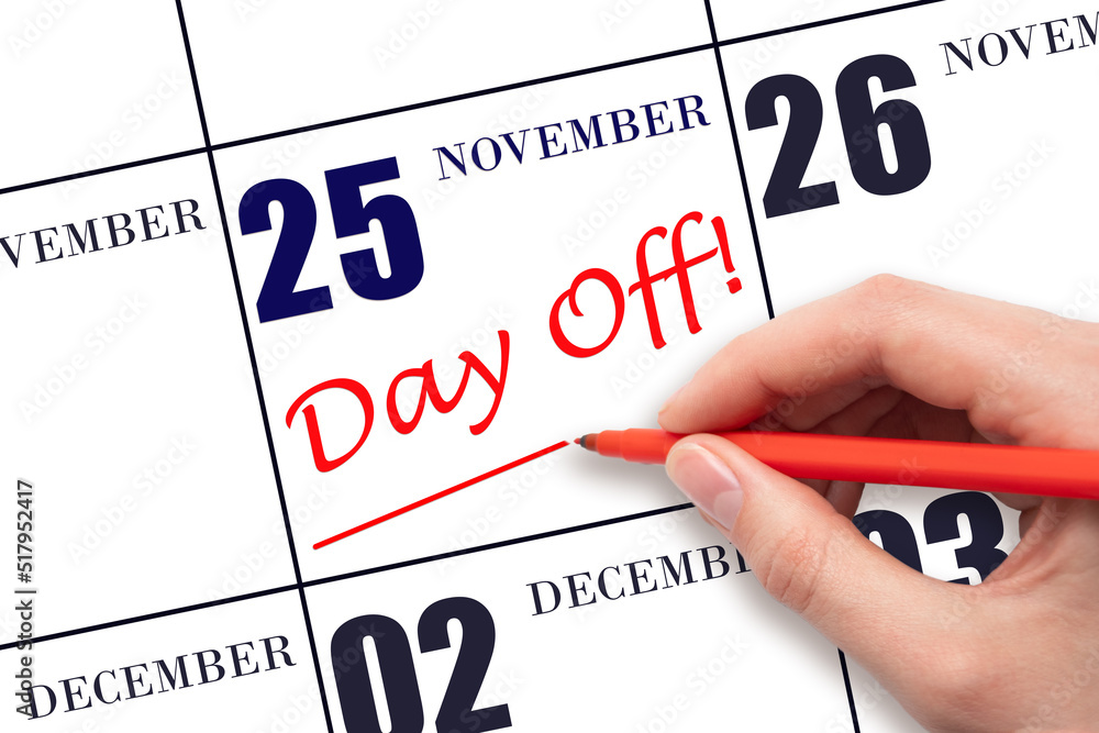 Hand writing text DAY OFF and drawing a line on calendar date 25 November. Vacation planning concept. Hand writing text DAY OFF and drawing a line on calendar date 25 November. Vacation planning concept.