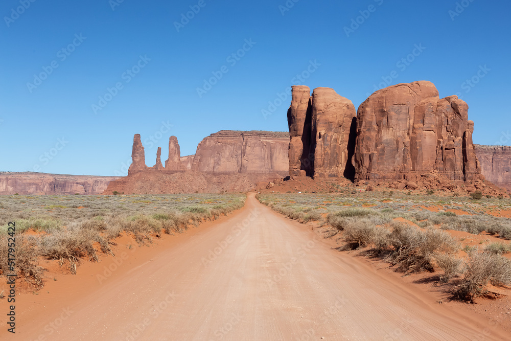 Scenic Dirt Road in the Dry Desert with Red Rocky Mountains in Background. Oljato-Monument Valley, Utah, United States.