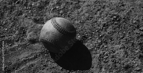 Baseball ball closeup on game field in black and white.