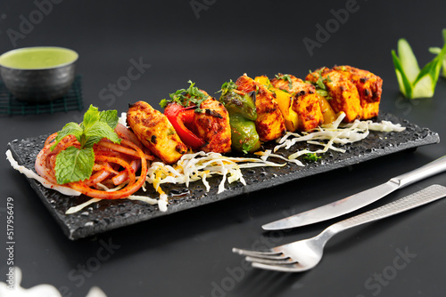 Paneer tikka is an Indian dish made from chunks of paneer marinated in spices and grilled in a tandoor photo