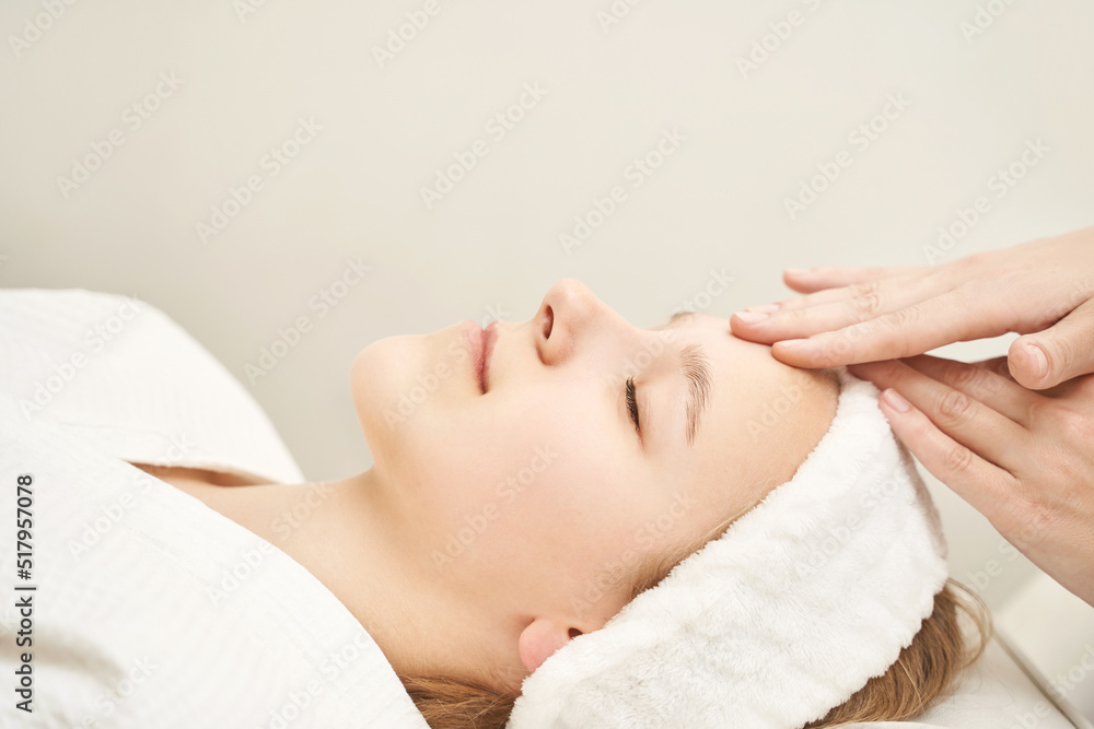 Face massage at luxury spa salon. Doctor hands. Pretty female patient. Beauty treatment. Healthy skin procedure. Young woman head. Light background. Facial rejuvenation dermatology mask. Detox therapy Face massage at luxury spa salon. Doctor hands. Pretty female patient. Beauty treatment. Healthy skin procedure. Young woman head. Light background. Facial rejuvenation dermatology mask. Detox therapy