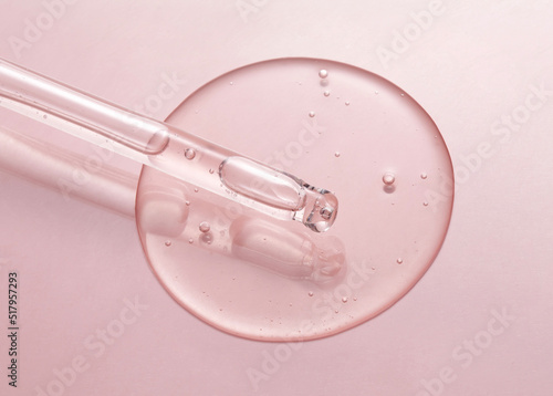 Cosmetic serum gel beauty drop and cosmetic pipette on pink color background. Skincare beauty product with bubbles texture.