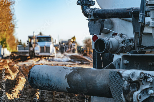 A close-up view of the pipe of heavy equipment in the quarry. Blur background of heavy industrial machinery, trucks.