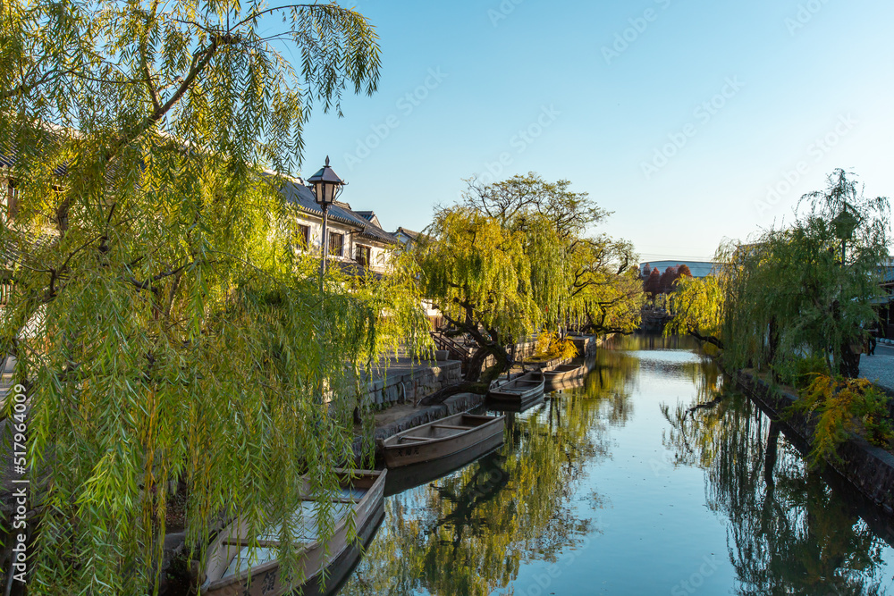 The townscape of Kurashiki Bikan Historical Quarter in sunny day. It is a historic area with old architectures, shops, restaurants and galleries situated along a canal.