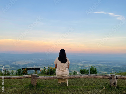 Young woman enjoying beautiful sunrise sky on the mountain.