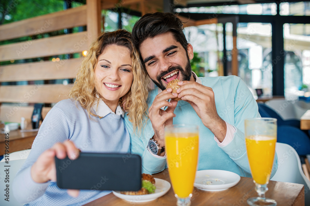 Young couple sitting in a cafe, having breakfast. Love, dating, food, lifestyle concept Young couple sitting in a cafe, having breakfast. Love, dating, food, lifestyle concept
