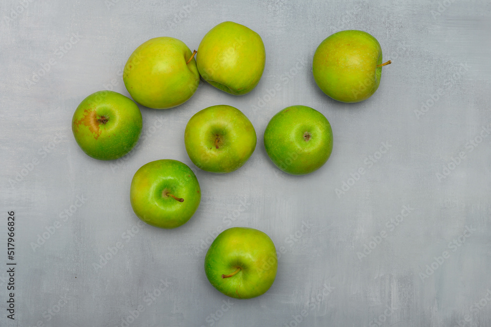 Still life photo of fresh green ripe apples on a grey rustic table. Still life food photography for many purposes Still life photo of fresh green ripe apples on a grey rustic table. Still life food photography for many purposes