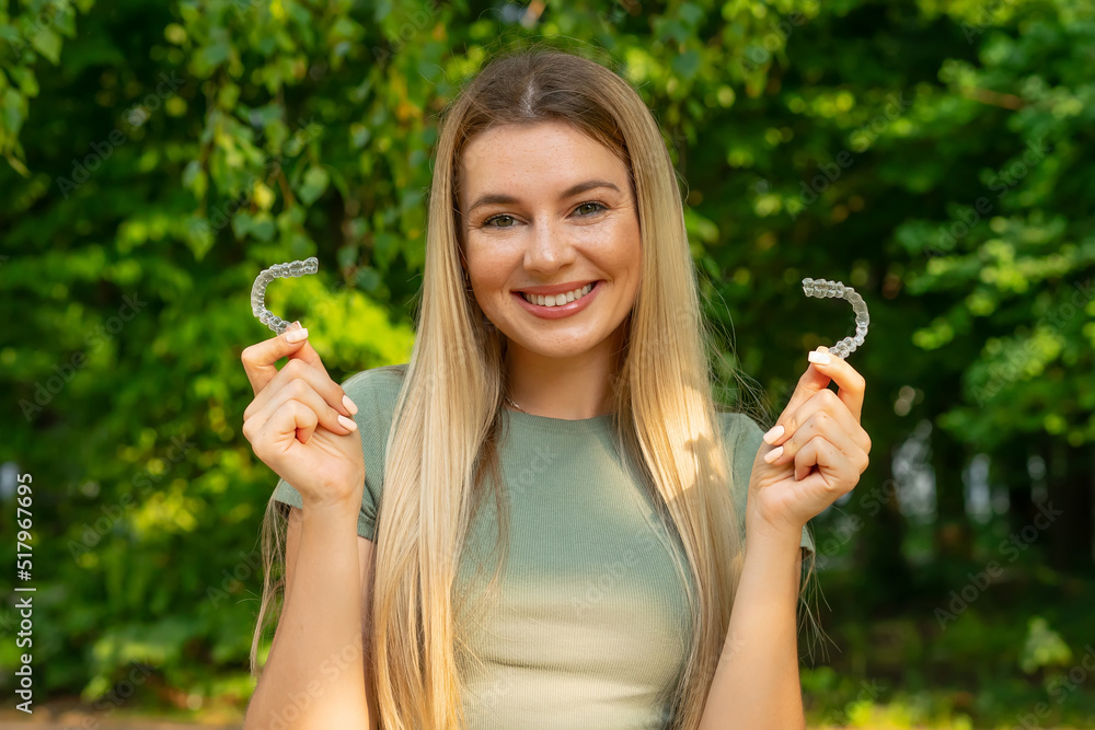 Teeth retainer for improving bite in hand of pretty girl. Teeth care. Orthodontic devices.Mobile orthodontic appliance for dental correction. Teeth retainer for improving bite in hand of pretty girl. Teeth care. Orthodontic devices.Mobile orthodontic appliance for dental correction.