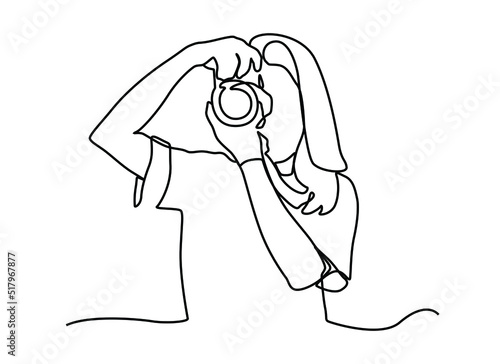 Continuous one line drawing happy photographer is taking photo using dslr camera. Female character standing full length and shooting. Young tourist woman photographer with a camera takes pictures.