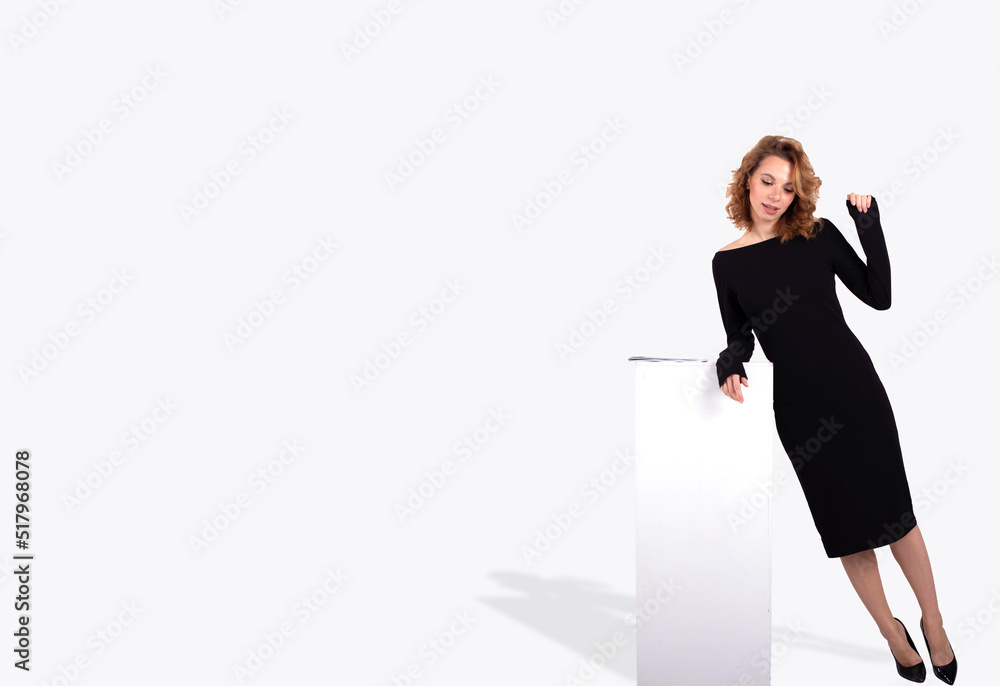 Beautiful business woman with red hair in a black dress and high heels shoes on the white background Beautiful business woman with red hair in a black dress and high heels shoes on the white background