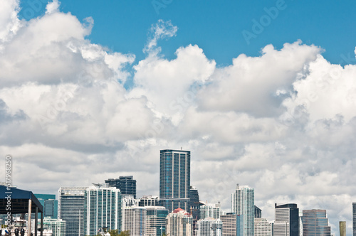 front view  far distance of the tropical  Miami  Florida skyline  at mid afternoon light with large white clouds